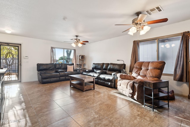 living room with ceiling fan, baseboards, tile patterned flooring, and visible vents