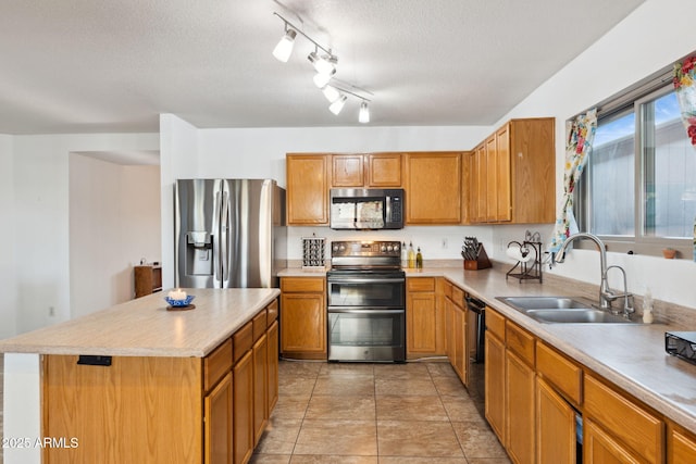 kitchen featuring a center island, light countertops, a textured ceiling, stainless steel appliances, and a sink