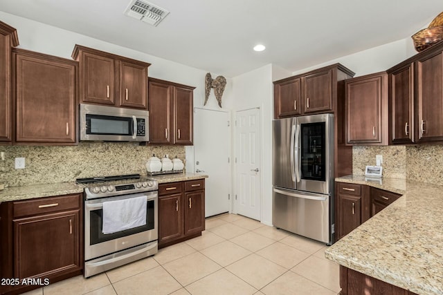 kitchen featuring light tile patterned flooring, dark brown cabinets, visible vents, and appliances with stainless steel finishes