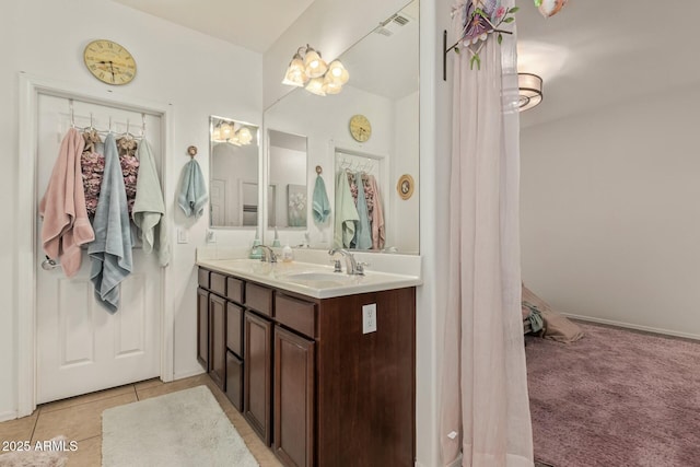 bathroom featuring tile patterned floors, visible vents, a sink, and double vanity