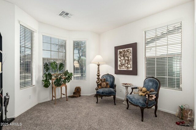 living area featuring carpet floors, visible vents, and baseboards