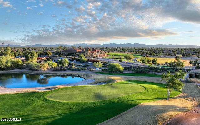 view of home's community with view of golf course and a water and mountain view
