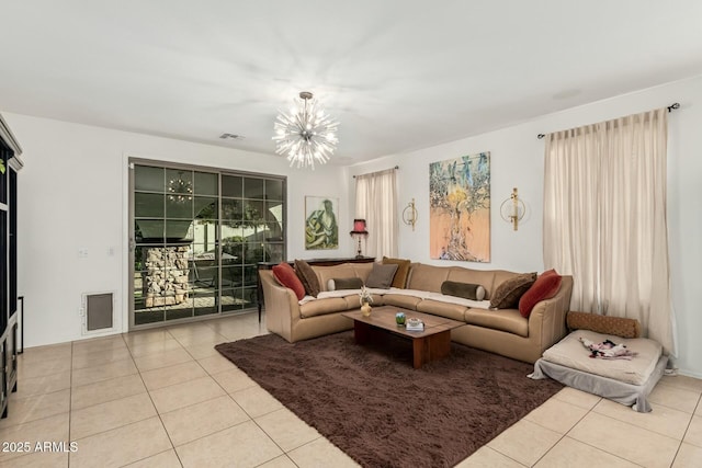 living area with visible vents, tile patterned floors, and an inviting chandelier