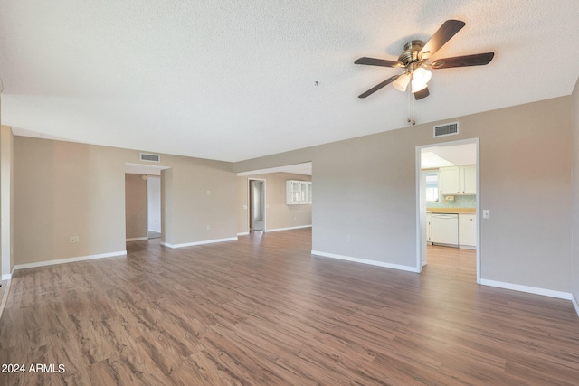 unfurnished living room with ceiling fan, a textured ceiling, and dark hardwood / wood-style flooring