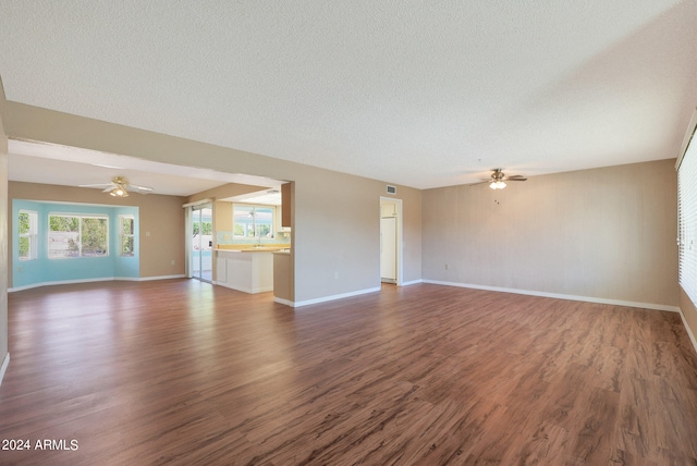 unfurnished living room featuring a textured ceiling, dark hardwood / wood-style floors, and ceiling fan