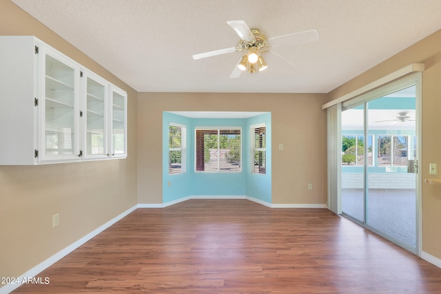 empty room with hardwood / wood-style floors, a textured ceiling, and ceiling fan