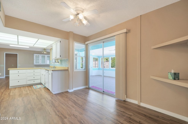 kitchen featuring white cabinets, kitchen peninsula, and light hardwood / wood-style flooring