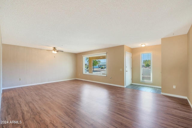 unfurnished living room featuring a textured ceiling and hardwood / wood-style flooring