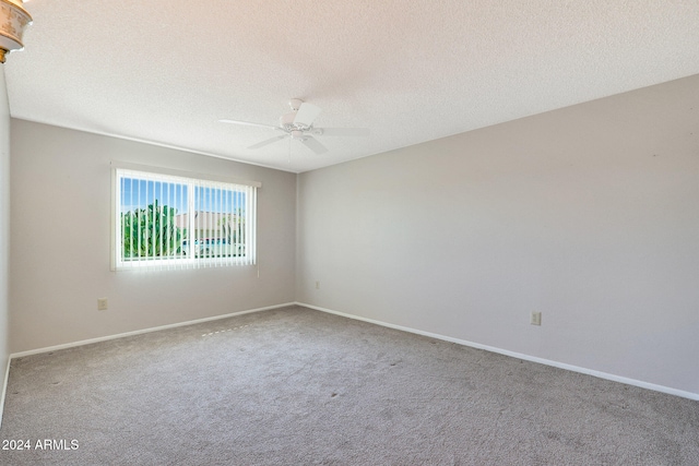 carpeted spare room with ceiling fan and a textured ceiling