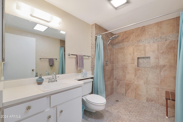 bathroom with vanity, toilet, curtained shower, and tile patterned flooring