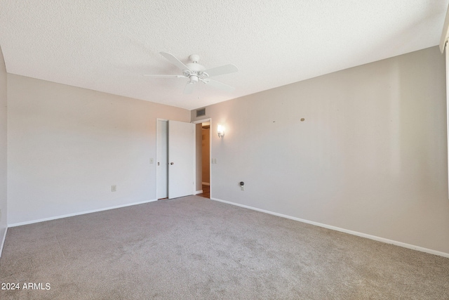 carpeted spare room with a textured ceiling and ceiling fan