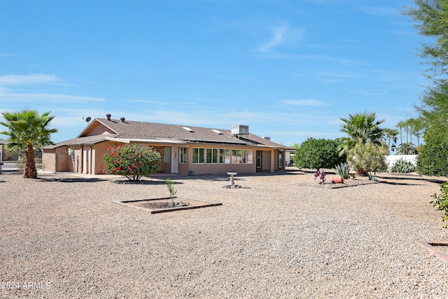 rear view of house featuring central AC