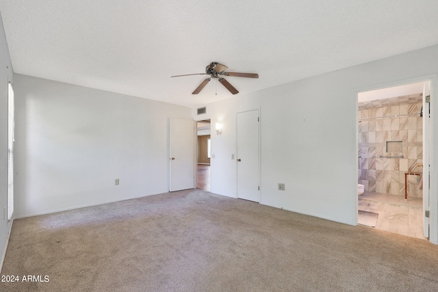 empty room with a textured ceiling, carpet flooring, and ceiling fan