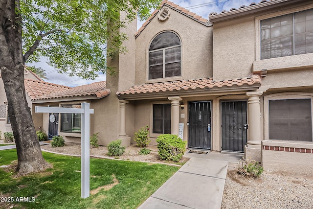 view of front of house featuring stucco siding and a tiled roof