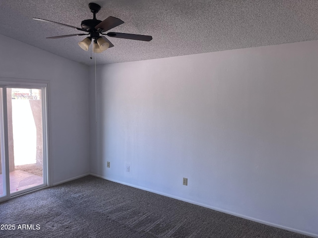 spare room featuring a textured ceiling, dark carpet, and a ceiling fan