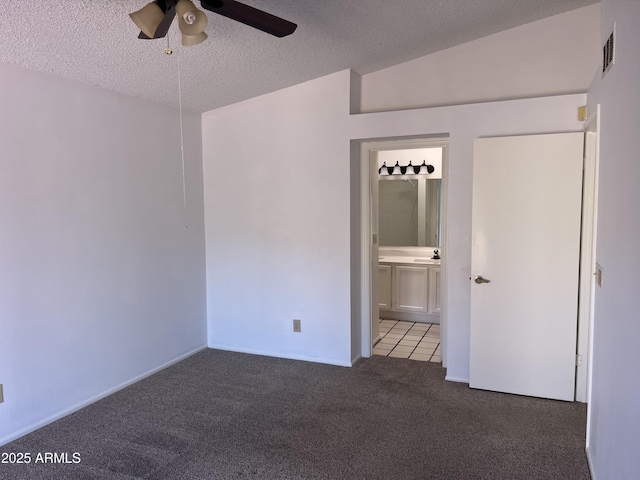 unfurnished bedroom featuring visible vents, a ceiling fan, ensuite bath, a textured ceiling, and carpet flooring