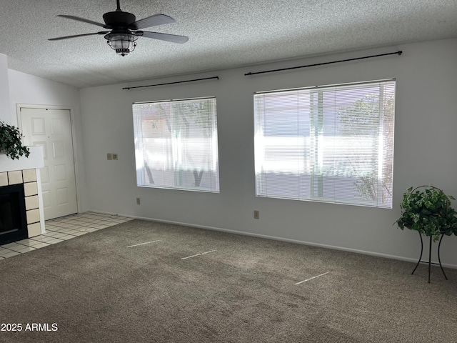 unfurnished living room with carpet floors, a fireplace, vaulted ceiling, a textured ceiling, and ceiling fan