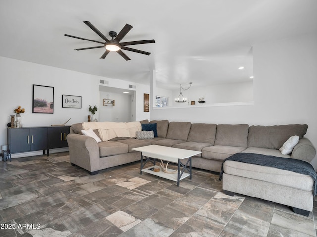 living room featuring ceiling fan with notable chandelier