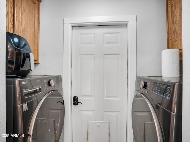 washroom with cabinets and washer and dryer