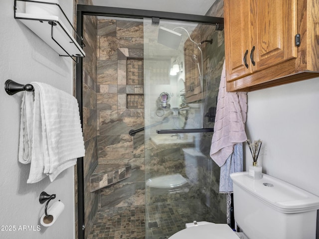 bathroom featuring a shower with door and toilet