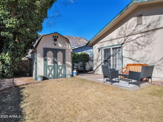 exterior space featuring a mountain view, a patio area, and a storage unit