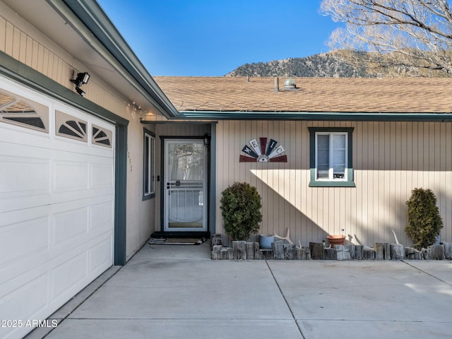 doorway to property with a mountain view and a garage