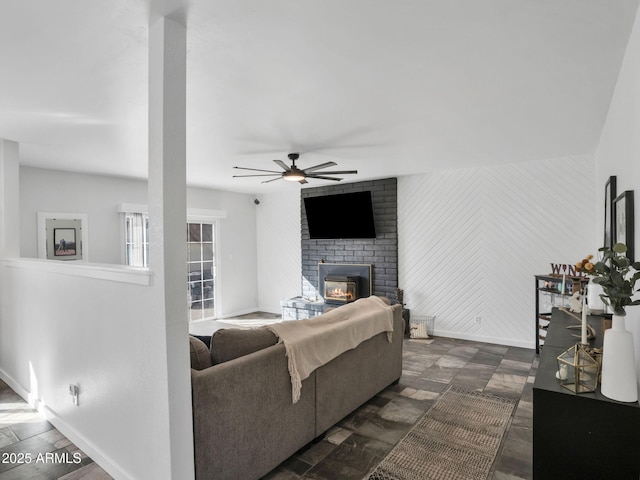 living room with ceiling fan and a brick fireplace