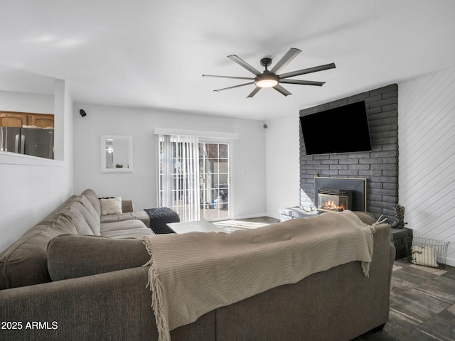 bedroom featuring stainless steel refrigerator, ceiling fan, and a brick fireplace