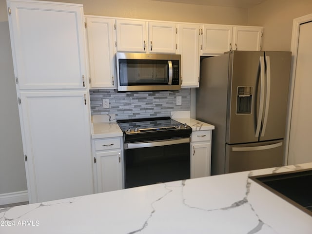 kitchen featuring backsplash, light stone counters, white cabinets, and appliances with stainless steel finishes