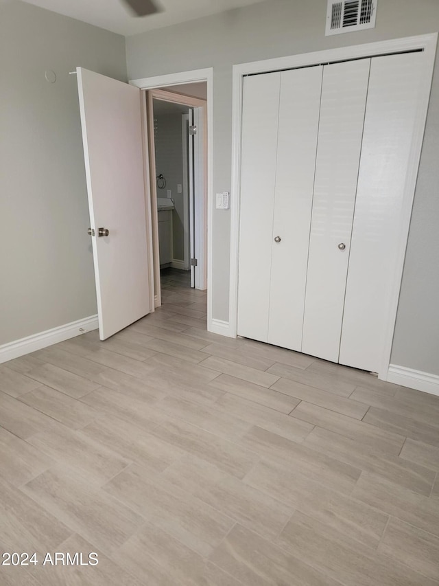 unfurnished bedroom featuring light hardwood / wood-style flooring and a closet