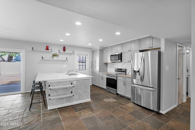 kitchen with open shelves, appliances with stainless steel finishes, a wealth of natural light, and baseboards