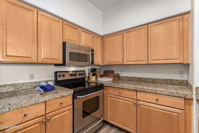 kitchen featuring stainless steel appliances, light brown cabinets, and light wood-type flooring