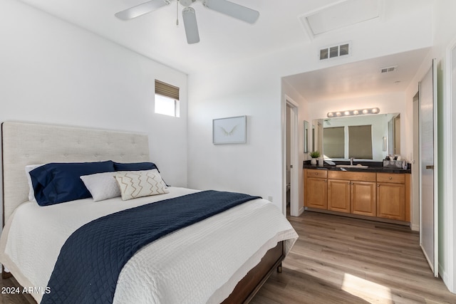 bedroom featuring light wood-type flooring, ceiling fan, and sink