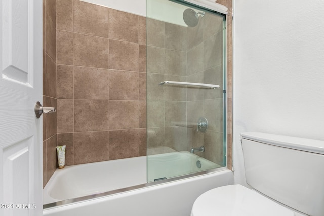 bathroom with combined bath / shower with glass door and toilet