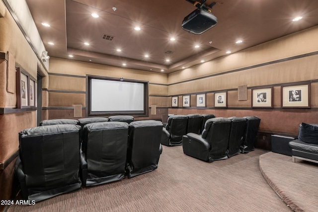 carpeted cinema featuring wood walls and a raised ceiling