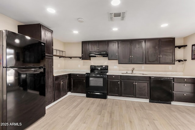 kitchen with dark brown cabinets, sink, light hardwood / wood-style flooring, and black appliances