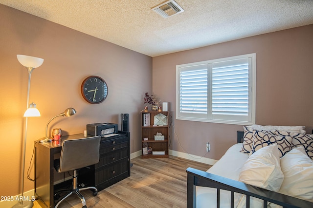 home office featuring a textured ceiling and light hardwood / wood-style floors