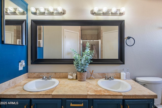 bathroom featuring a shower with door, vanity, and toilet