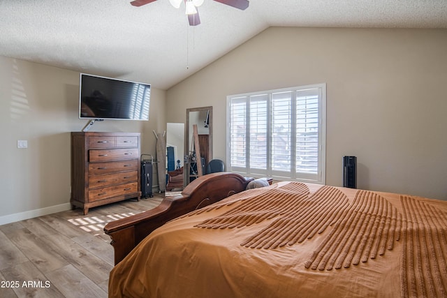 bedroom featuring lofted ceiling, ceiling fan, light hardwood / wood-style floors, and a textured ceiling