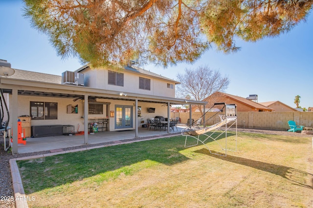 rear view of property with a lawn, french doors, ceiling fan, central AC, and a patio area