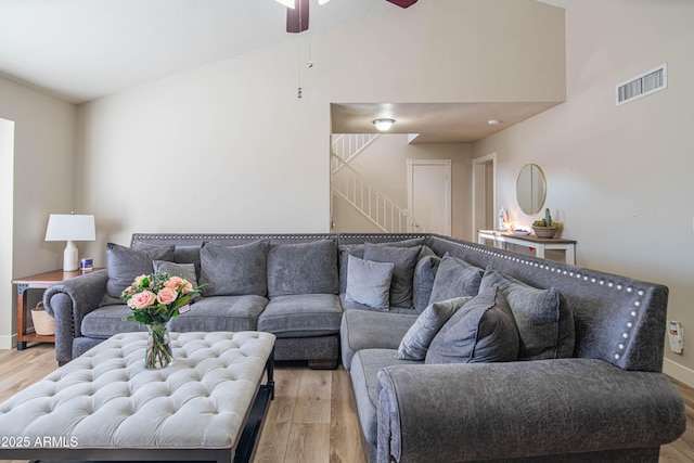 living room featuring ceiling fan, high vaulted ceiling, and light hardwood / wood-style floors