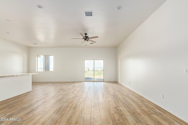 spare room with light wood-type flooring, visible vents, and a ceiling fan