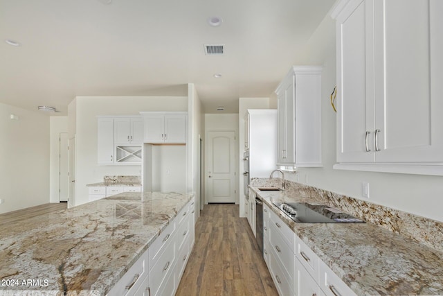 kitchen featuring light stone counters, white cabinets, visible vents, and black electric cooktop