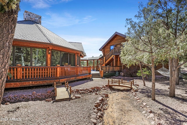 rear view of property featuring a wooden deck