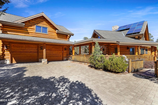 view of front facade with solar panels and a garage