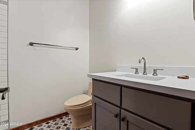 bathroom with toilet, tile floors, and vanity