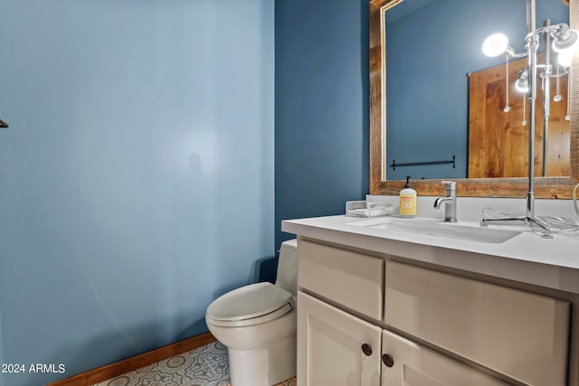 bathroom with toilet, tile floors, and vanity