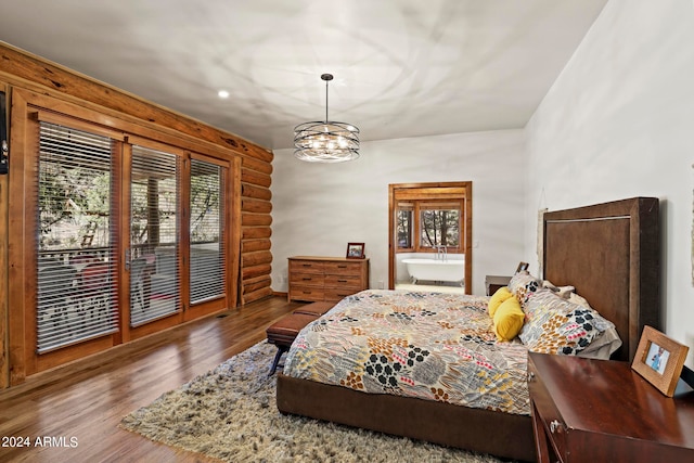 bedroom with dark hardwood / wood-style floors, access to exterior, and a chandelier