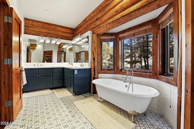 bathroom with a tub, rustic walls, tile floors, and dual bowl vanity