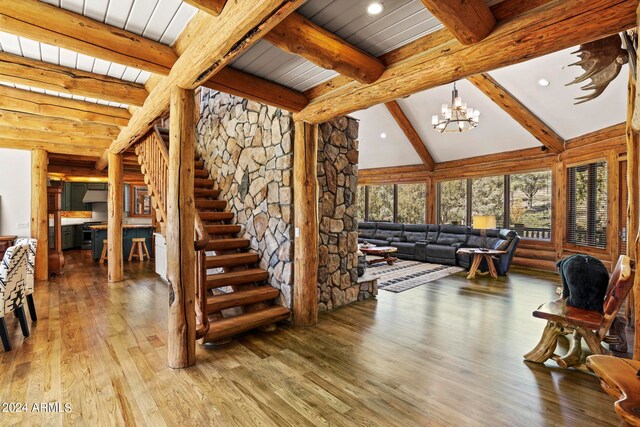 interior space featuring lofted ceiling with beams, a notable chandelier, and dark hardwood / wood-style floors